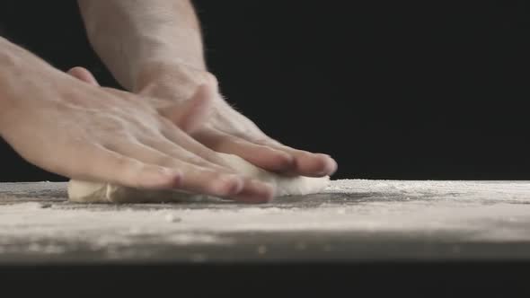 Male Hands Divide Baking Dough Into Shares on a Board Sprinkled with Flour alt
