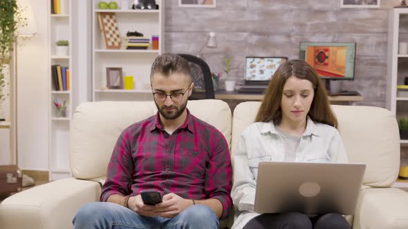 Beautiful Couple Sitting on the Couch and Doing Online Shopping alt