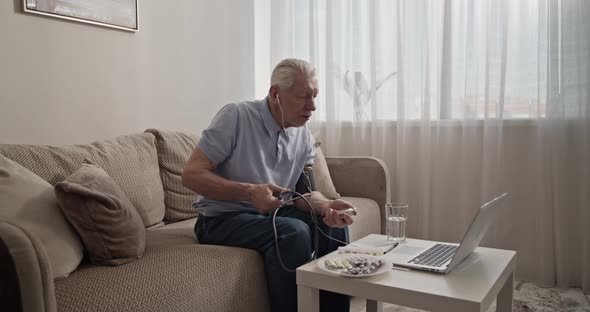 Pensioner Measuring Blood Pressure During Online Appointment alt