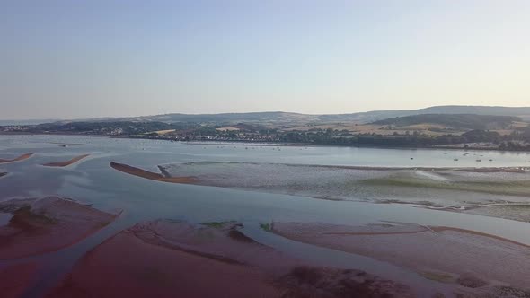Sky view of historic town in Southwest England. The town is visible in the distance with lushes hill alt