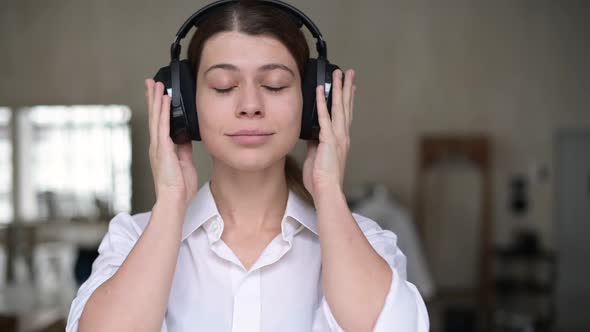 woman puts on headphones, turns on music, closes her eyes and her mood improves alt
