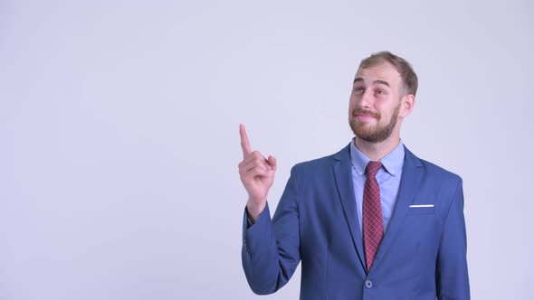 Happy Bearded Businessman Thinking and Pointing Up