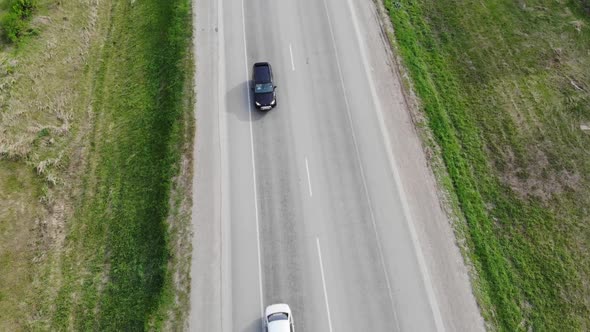 Aerial View From Drone Above Cars Driving Along Empty Countryside Road on Sunny Day