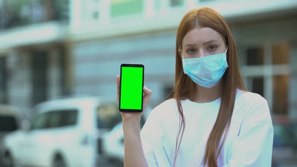 Girl in Sick Mask Holding Green Screen Phone, Appointment With Doctor Online alt