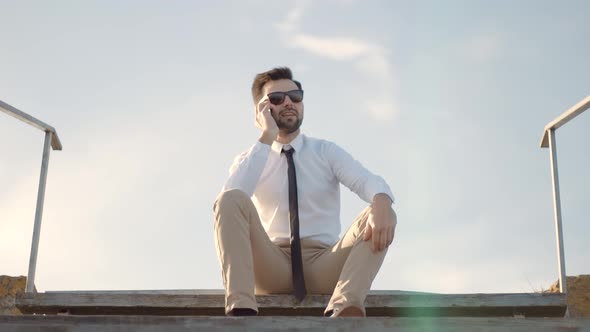 Businessman Talking On Cellphone. Man In Sunglasses Using Mobile Phone And Call. alt