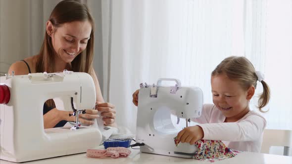 A mother and a daughter are spending time at sewing and talking. Panoramic view. alt
