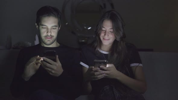 Couple Using Smartphones at Home alt