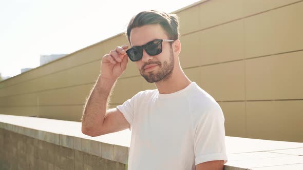 Portrait of handsome stylish hipster man posing outdoors alt