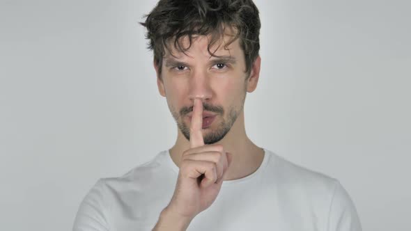 Portrait of Young Casual Man Gesturing Silence Finger on Lips alt