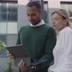 Multiracial Positive Man and Adult Woman Holding Tablet and Talking