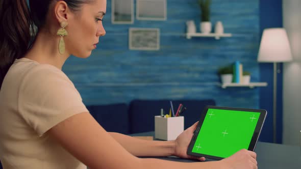 Freelancer Reading Online Book Using Tablet Computer with Mock Up Green Screen Display alt