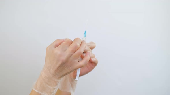 The doctor holds in his hands a medical syringe with medicine before an injection alt