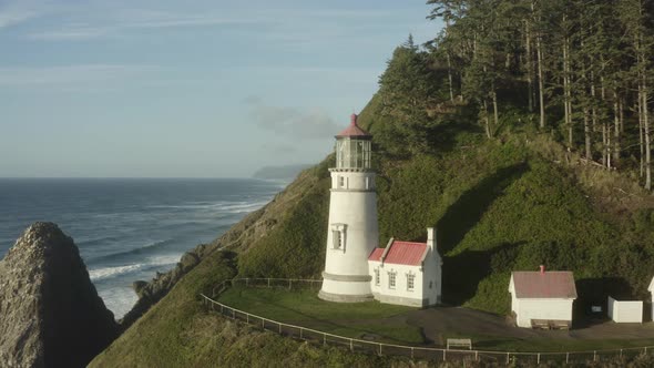 Aerial flying close to Haceta Head lighthouse with coastline in background alt