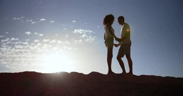 Couple standing on rock at beach 