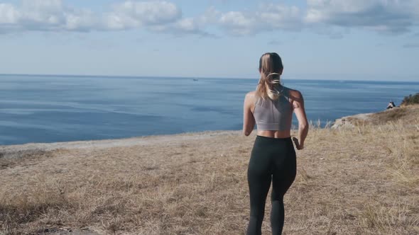 Backside View of Woman Running Outdoors, Beautiful View on Ocean, Slow Motion alt