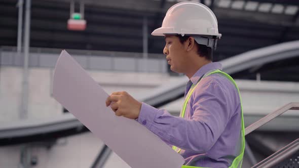 Civil engineer work inspecting architect drawing on construction site.