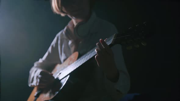 Girl Playing Guitar at Dark Studio