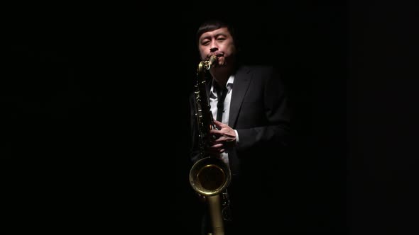 Man Musician Enjoying Playing the Saxophone in Darkness alt