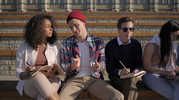 Multi-ethnic Cheerful Friends Girls and Guys Preparing for University Exam Together alt