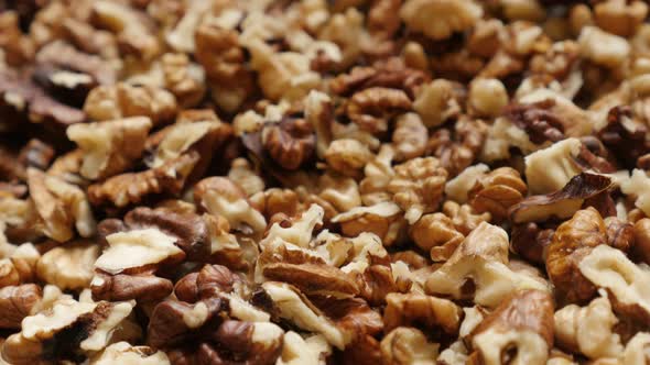 Low tilt on Juglans regia fruit ingredient pieces 4K 2160p 30fps UltraHD footage - Pile of walnut ou alt