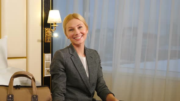 Smiling Woman in Hotel with Bright Light Outside alt