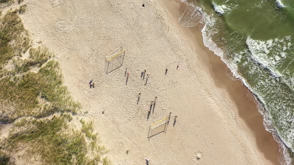 AERIAL: Top View Shot of Football Players Playing Ball on a Sandy Beach