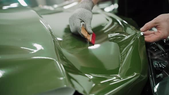 Process of Vinyl Wrapping a Car in Dark Green Color Using Plastic Cards