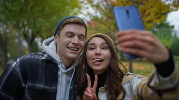 Positive Young Lovers Making Funny Faces on Selfie Outdoor alt