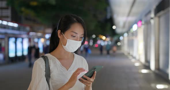 Woman wear face mask and use of mobile phone at street