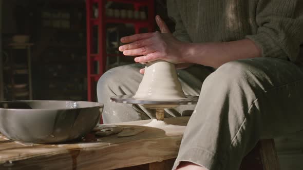 Woman Is Working With Raw Clay On Potter's Wheel alt