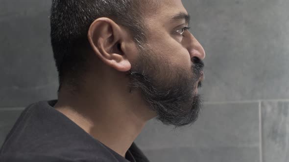 Ethnic Minority Adult Male Gargling Mouthwash In Bathroom. Side View, Locked Off alt