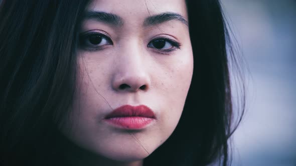 Serious proud chinese woman turn her head and stares camera,close up alt