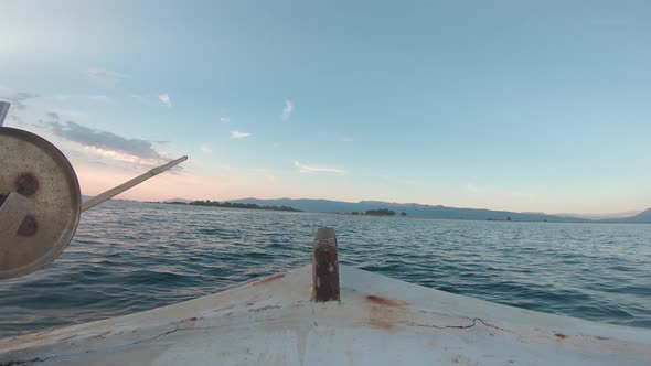 Point of view from inside of a sailing fishing boat. Sailing forward into the sunset. Calm water out alt