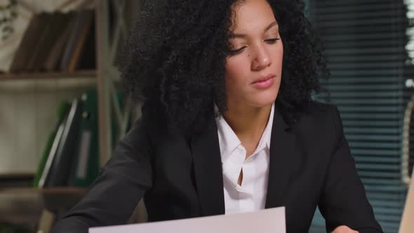 Portrait of African American Woman is Viewing Charts and Graphs Composing Report alt