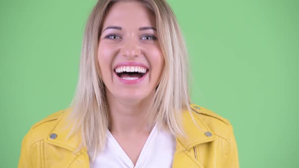 Face of Happy Young Rebellious Blonde Woman Smiling and Laughing alt