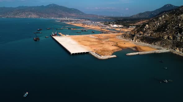 Building massive harbor of Ca Na in Vietnam, aerial drone view over blue ocean alt