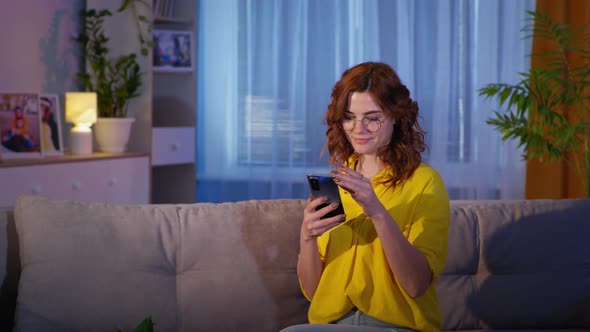 Girl in Glasses with Smartphone in Her Hands Uses Phone to Shop on Internet in an Online Store alt