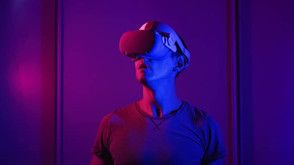 Young Man Watches 360 Media Content in VR Helmet alt