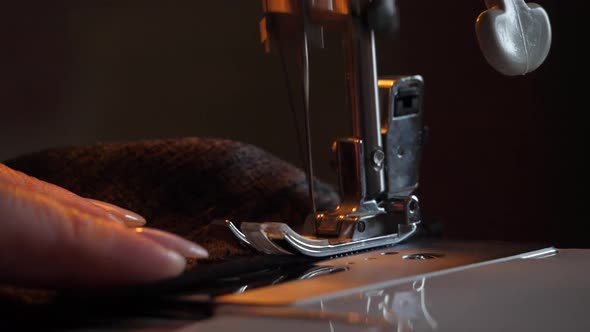 Sewing Machine Needle in Motion. Close-up of sewing machine needle rapidly moves up and down. The ta alt