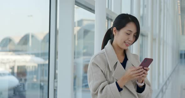 Businesswoman use of mobile phone in the airport alt