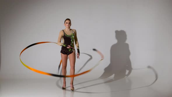 Gymnast Gracefully Move with a Ribbon in His Hands. White Background alt