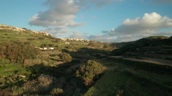 AERIAL: Slow Flight Above Paddy Fields and Greenery Farmlands in Malta in Winter alt