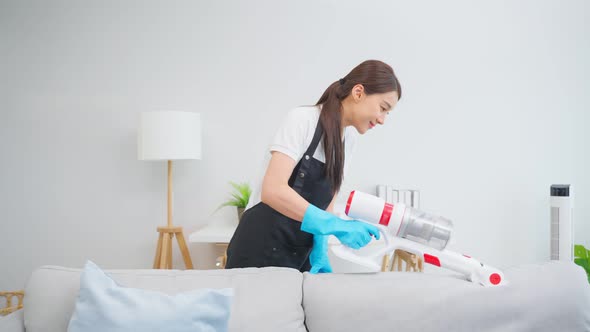 Asian cleaning service woman worker cleaning in living room at home. alt