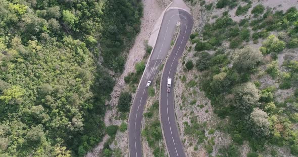 Top Down Shot of 2 Cars Driving on a Curvy Road on Serpentines in France