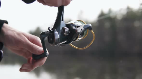 The guy in his free time catches a predatory fish on spinning from the shore. Fishing as a hobby. alt