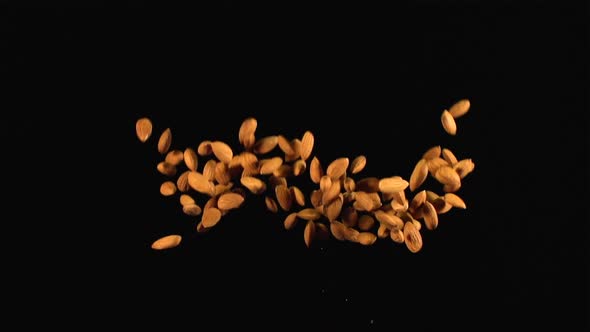 A heap of almonds up and down on a dark background