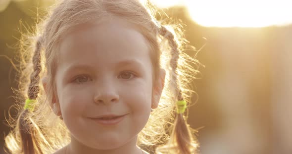 Charming Little Girl Blowing Dandelion While Walking