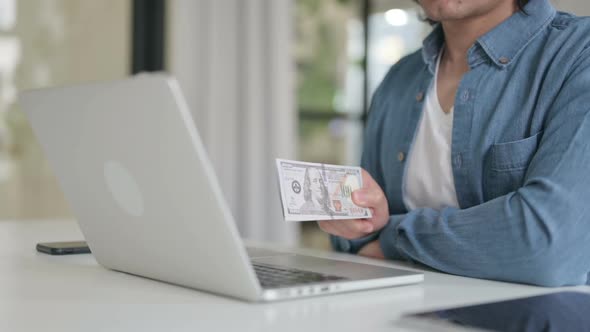 Close Up of Man Investing Dollars Through Laptop alt