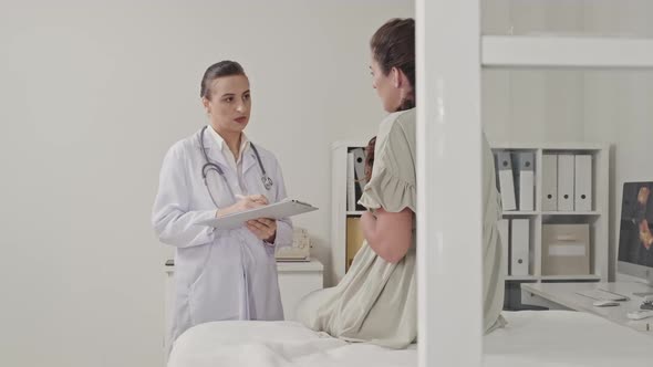 Doctor Listening to Pregnant Woman during Prenatal Checkup alt