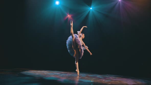 Ballet. Graceful ballerina dancing elements of classical ballet in the beautiful light and smoke on